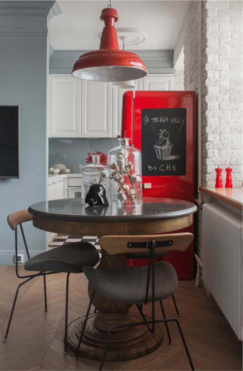 Vitt kök med grå väggar och ett rött kylskåp