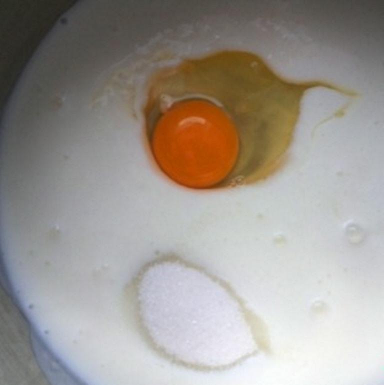 Adăugați un ou și zahăr într-un recipient cu chefir la temperatura camerei