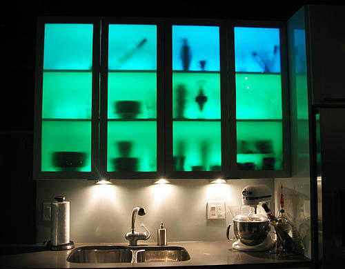 Belysningen i skåp med glasdörrar är mycket imponerande och ovanlig, och om du gör belysningen i olika färger kan du ändra kökets inre med ett tryck på en knapp på fjärrkontrollen