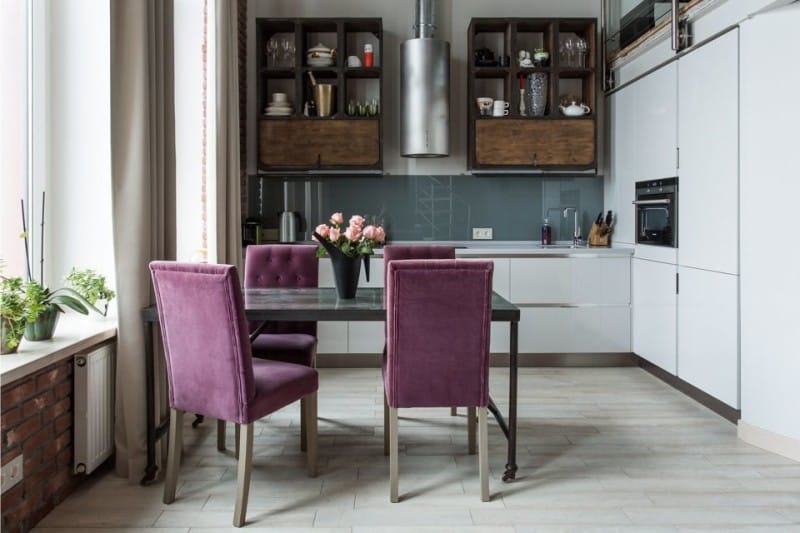 Loft -tyylinen keittiö, jossa tuolit violetilla verhoilulla
