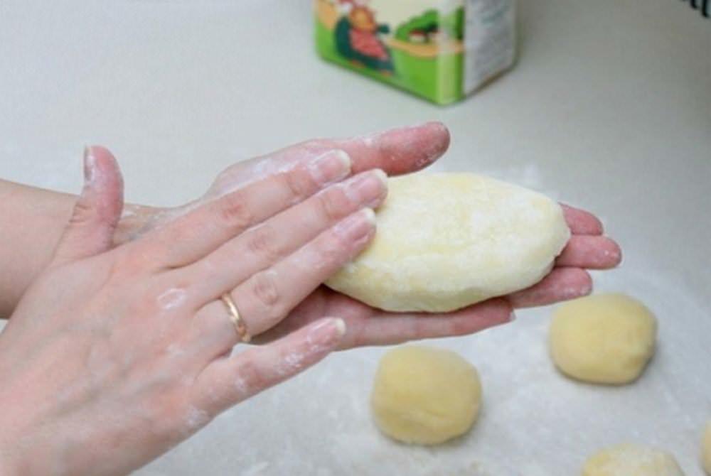 Τυλίξτε τις μπάλες σε σχήμα τηγανίτας, βάλτε τη γέμιση μέσα και τυλίξτε το