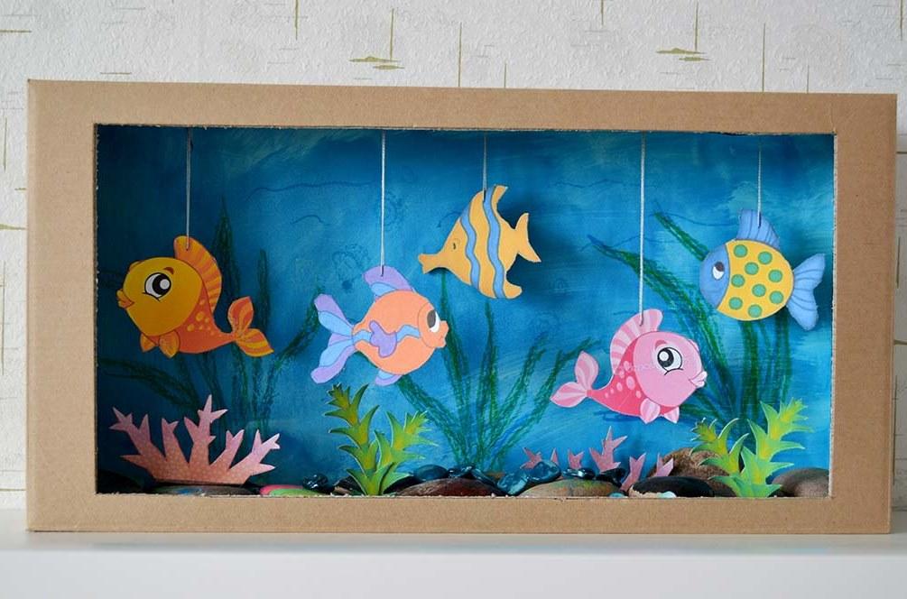 Akvaario, jossa on kauniita kaloja, jotka on valmistettu käsin pahvista ja paperista, näyttää erittäin mielenkiintoiselta ja epätavalliselta.