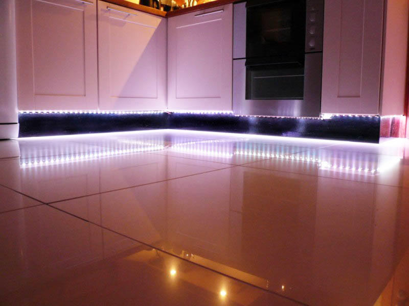 Εάν το πάτωμα της κουζίνας είναι γυαλιστερό, τότε δεν συνιστούμε τη χρήση του οπίσθιου φωτισμού LED από το κάτω μέρος των ντουλαπιών στην αρχική τους μορφή. Είναι καλύτερα να το τροποποιήσετε τοποθετώντας το σε θήκη με παγωμένο γυαλί. Σε αυτή την περίπτωση, τα LED δεν θα αντανακλούν στο πάτωμα και ο οπίσθιος φωτισμός θα είναι μαλακός και διακριτικός.