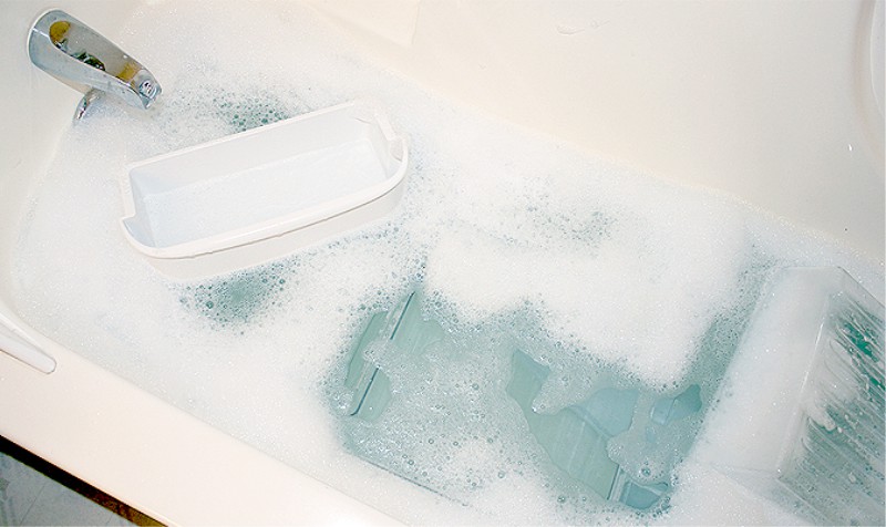 Blötlägg de avtagbara delarna av kylskåpet i badkaret