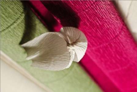 Utilisez du ruban adhésif pour attacher les pétales à la tige. Une fleur faite de bonbons et de papier ondulé est prête.