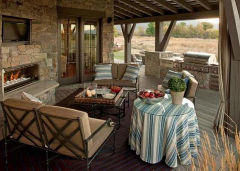O bucătărie de vară cu verandă deschisă poate face parte din casă, combinată cu un acoperiș