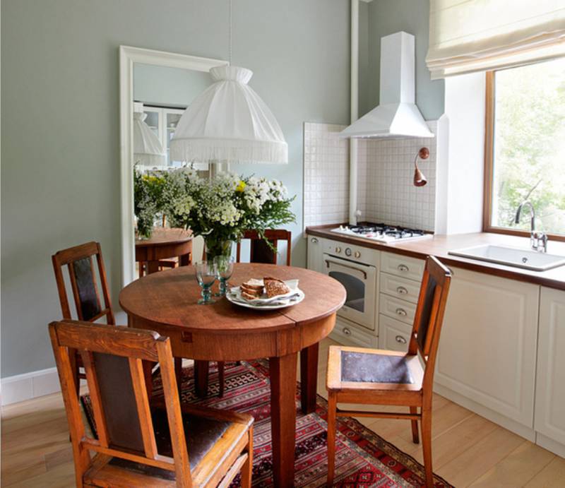 Okrúhly malý drevený stôl v interiéri malej kuchyne