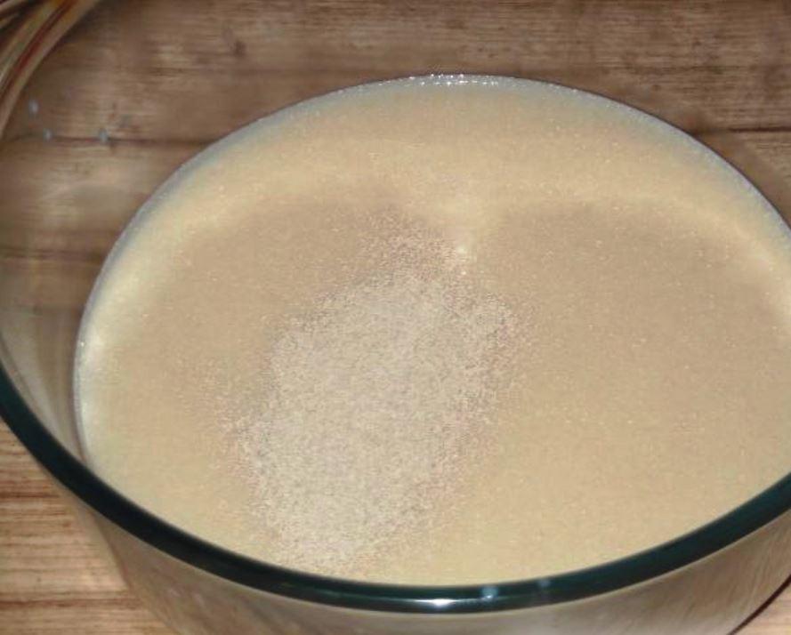 Ρίξτε 2 φλιτζάνια ζεστό γάλα και ξηρή μαγιά σε ένα ρηχό δοχείο