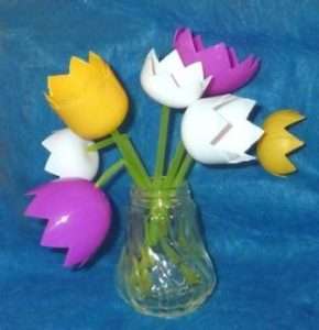 Vous pouvez faire un bouquet printanier de tulipes à partir d'œufs en plastique sous une agréable surprise. Sinon, prenez des bouteilles de yaourt. Les tubes à cocktail verts deviendront de belles tiges.