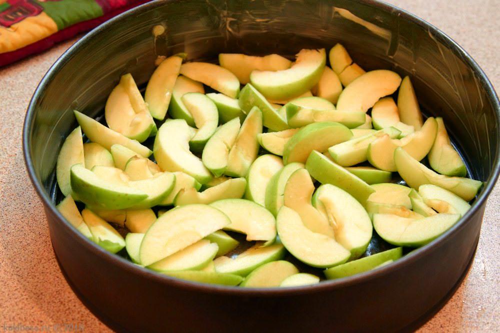 Skär äpplena i lika stora bitar och lägg dem på formens botten