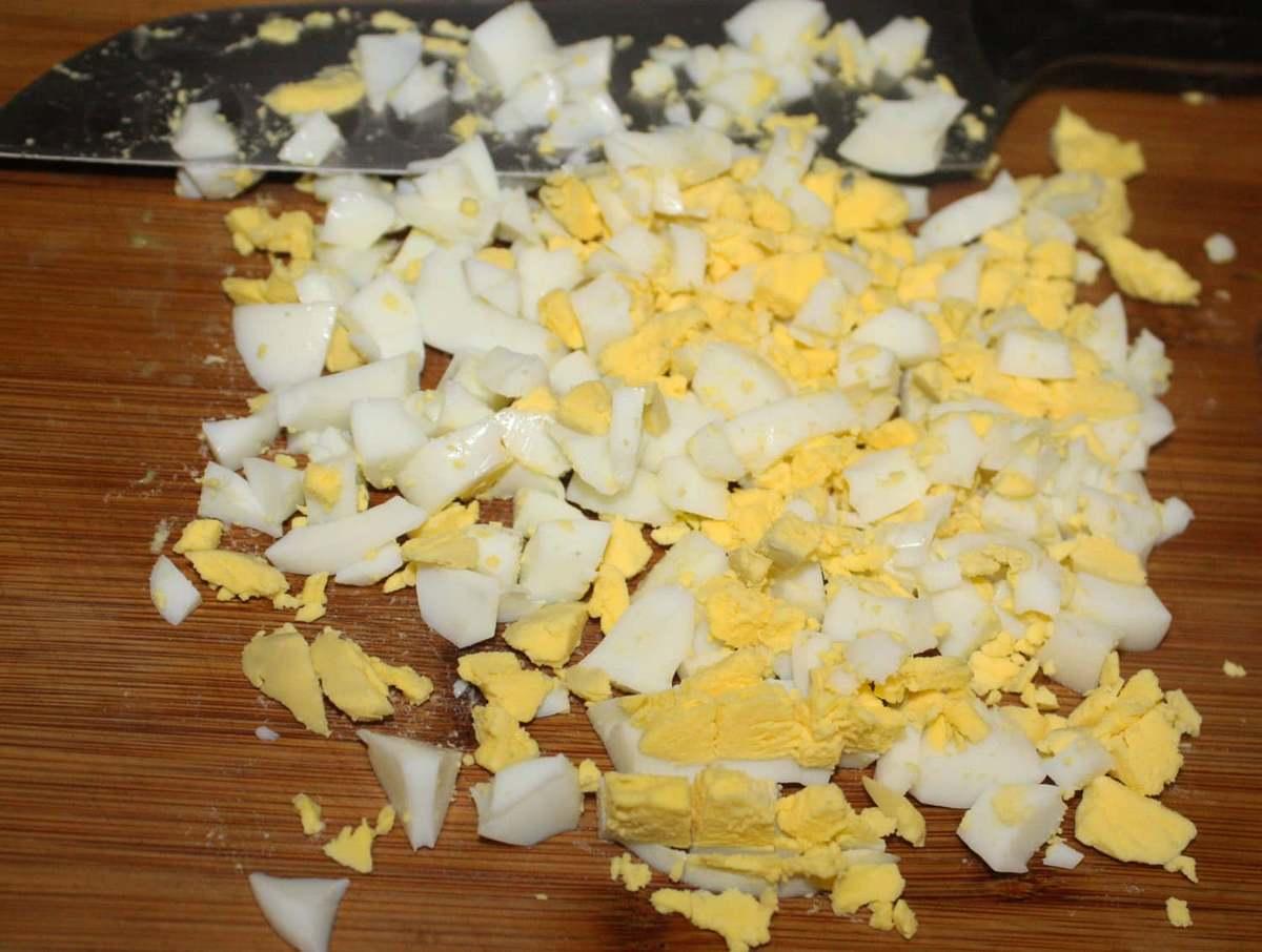 Gătirea umpluturii: fierbeți ouăle abrupte, apoi tocați mărunt, adăugați ceapa și brânza tocate. Condiment de neuitat cu sare după gust