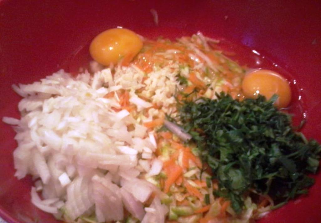 Προσθέστε ψιλοκομμένα κρεμμύδια, μυρωδικά και αυγά στα κολοκυθάκια και τα καρότα